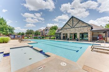 A large outdoor swimming pool with a building in the background.